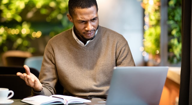 Man looking at laptop wondering what the NJ PLIGA surcharge is