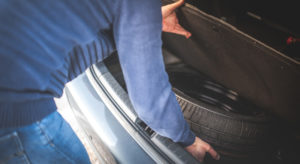 Man checking on a spare tire to see how long it can last in storage.