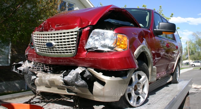 Totaled red suv on flat bed