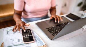 Woman calculating how to lower car insurance in NJ